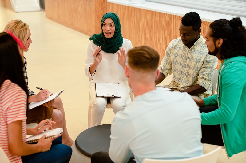 Een groep mensen is met elkaar in gesprek