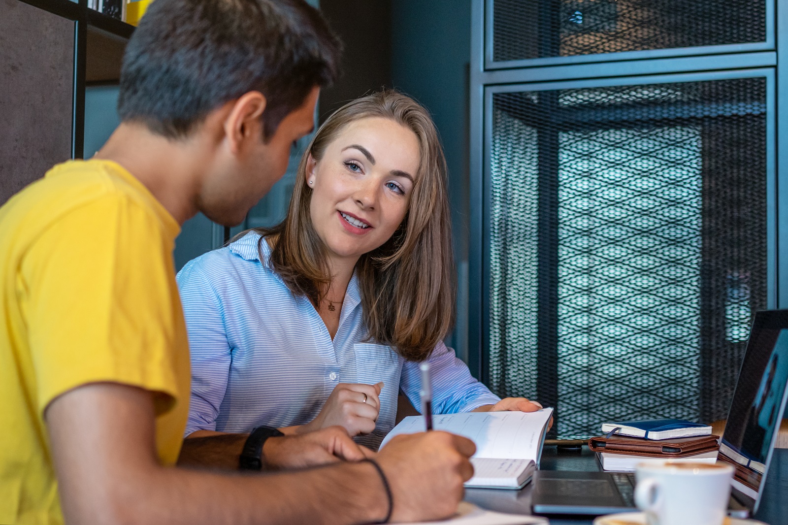 Een vrouw helpt een jongen met schrijven